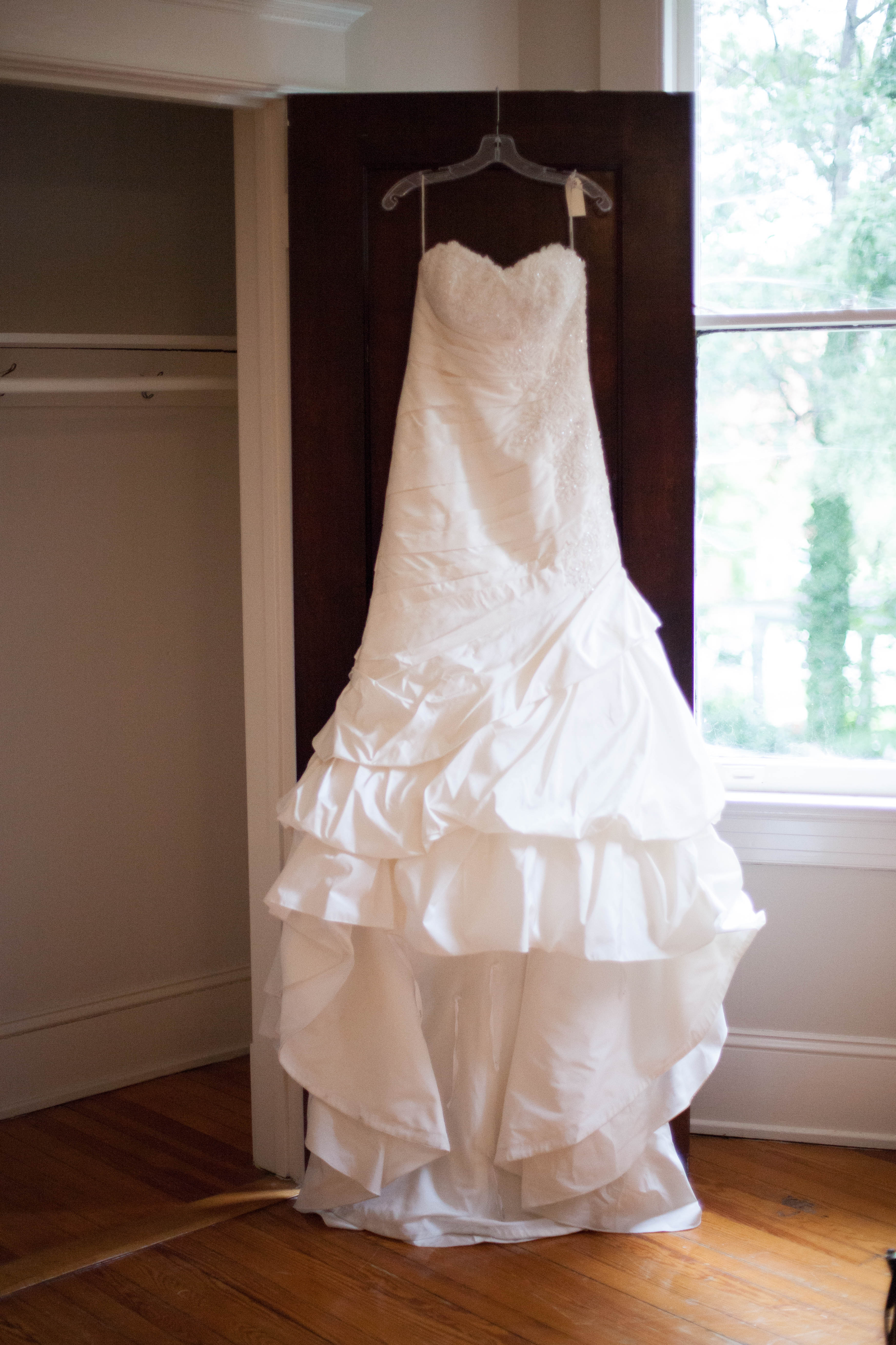 picture of bridal gown hanging on the top of a wooden door at The Tucker House in downtown Raleigh