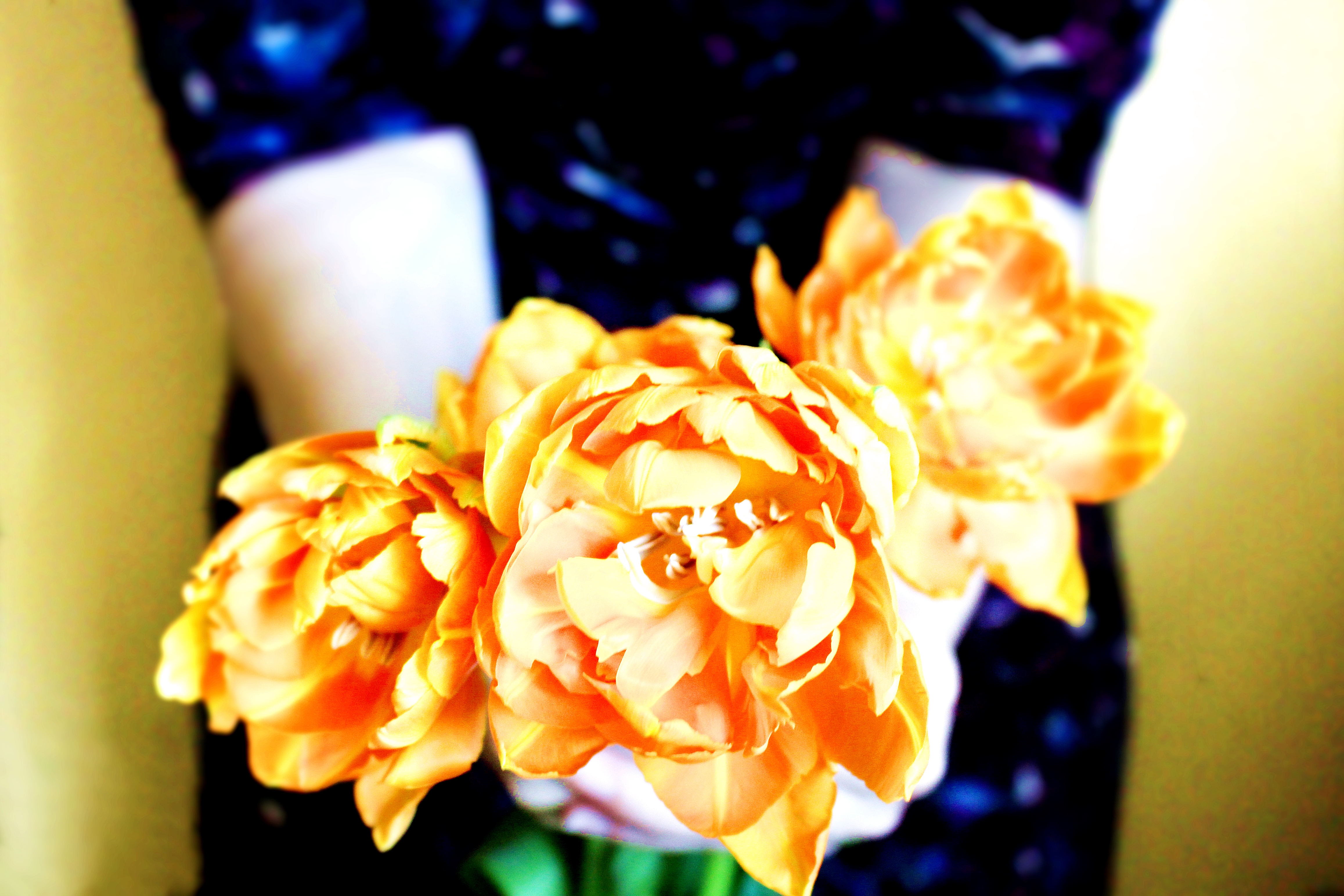 wedding trends bright orange flowers held by girl in sparkly navy sequin dress