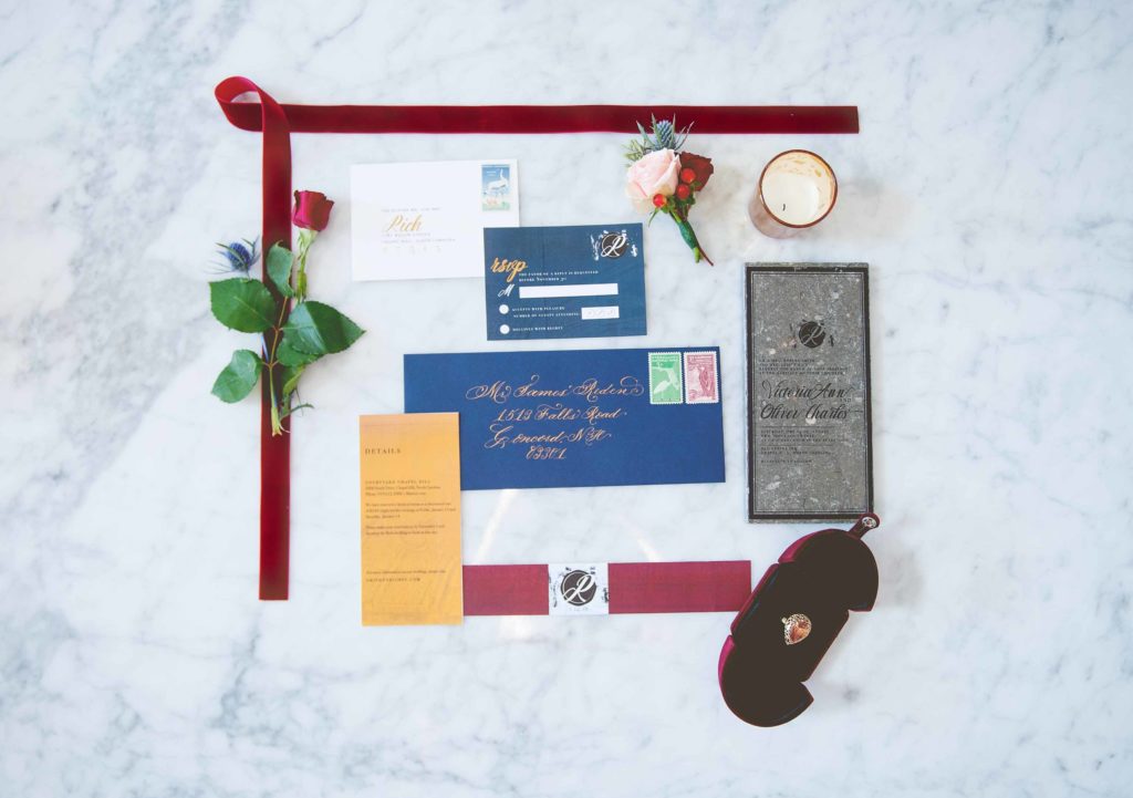 wedding invitation flatlay navy and burgundy on marble background